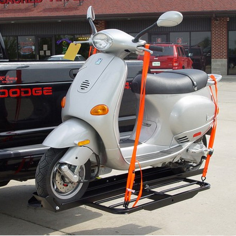 Single 50cc Scooter Carrier with Ramp, shown attached to a silver scooter with orange straps, parked near a truck. Ideal for transporting 49-50cc scooters, featuring a compact, sturdy design.