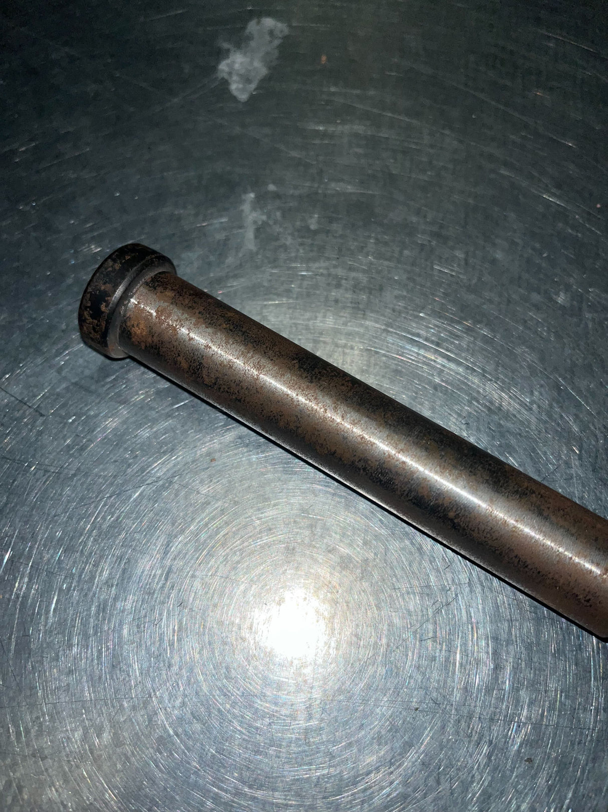 9.20 Sprocket Shaft for the Realtree RTK200 196cc Go-Kart (Blemished) on a metal surface, showing minor surface rust on the steel rod with a threaded end and stepped design.