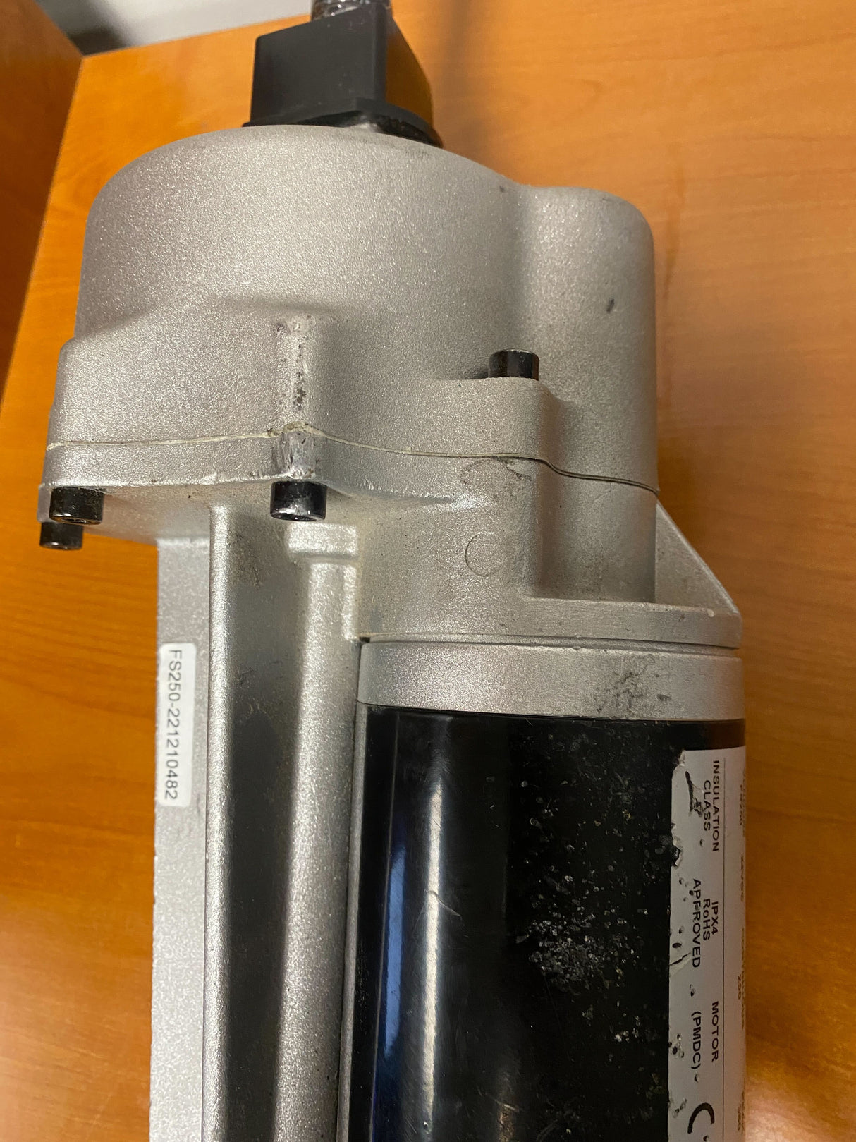 Motor, Brake, & Transaxle Assembly for the Go-Go Elite Traveller Plus (SC53/SC54) & Sport (S73/S74) (Blemished), showing a silver and black electric motor with visible scrapes on a wooden surface.