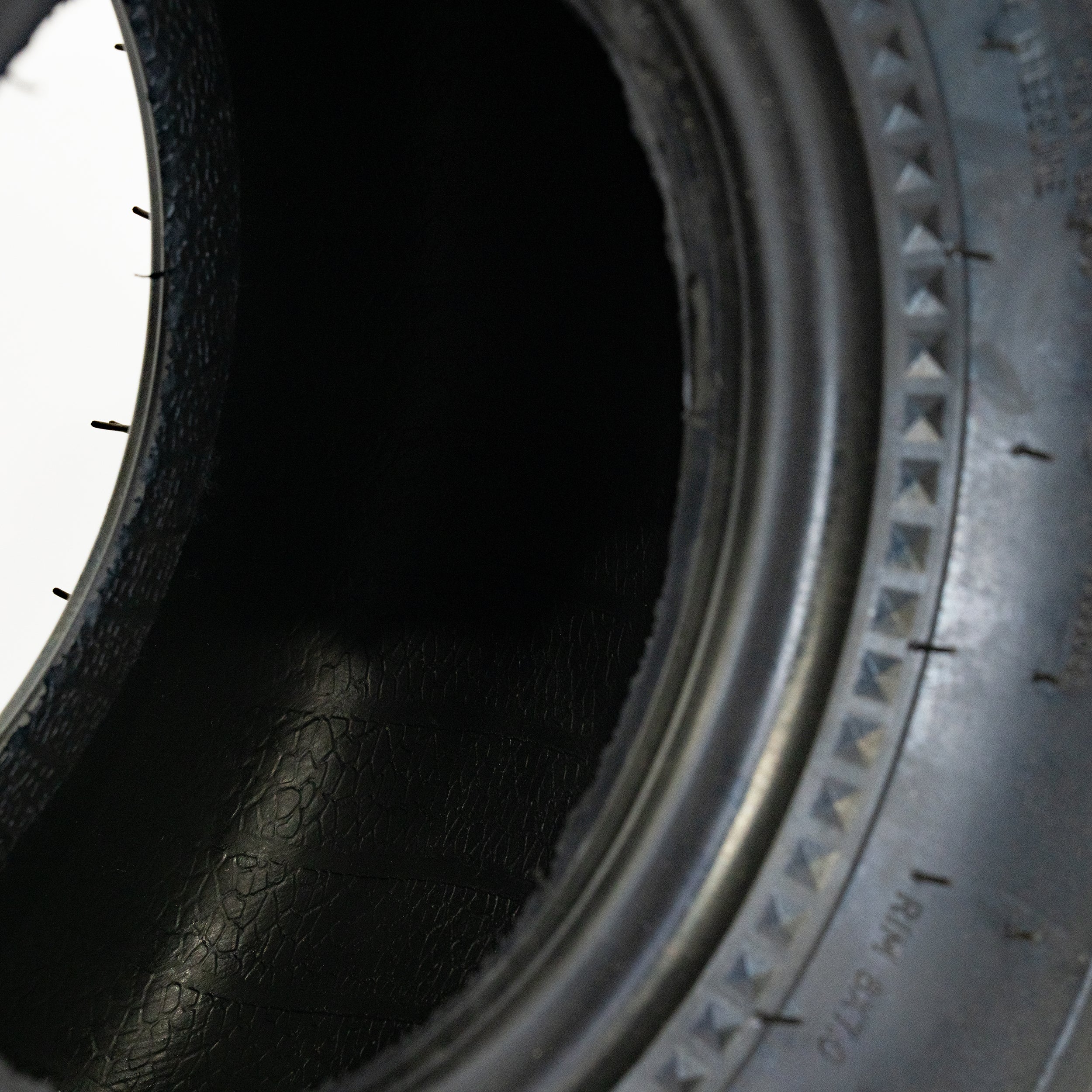 Close-up of the 18x9.5-8 Rear Tire for Coleman AT125-EX & AT125-UT ATVs, showcasing its knobby tread designed for effective performance on soft surfaces.