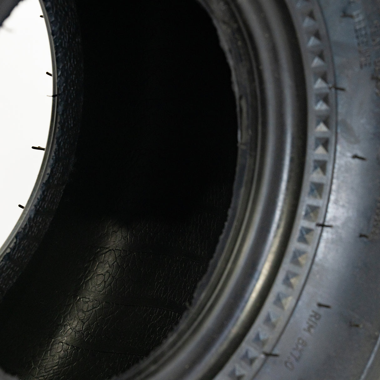 Close-up of the 18x9.5-8 Rear Tire for Coleman AT125-EX & AT125-UT ATVs, showcasing its knobby tread designed for effective performance on soft surfaces.