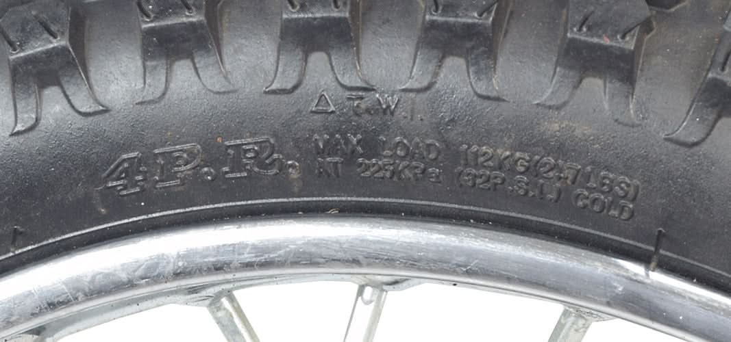Close-up of the 14 (2.50-14) Front Wheel Assembly for Dirt Bikes, featuring a knobby tire with visible text, inner tube, and wheel bearings, compatible with various 50cc dirt bike models.