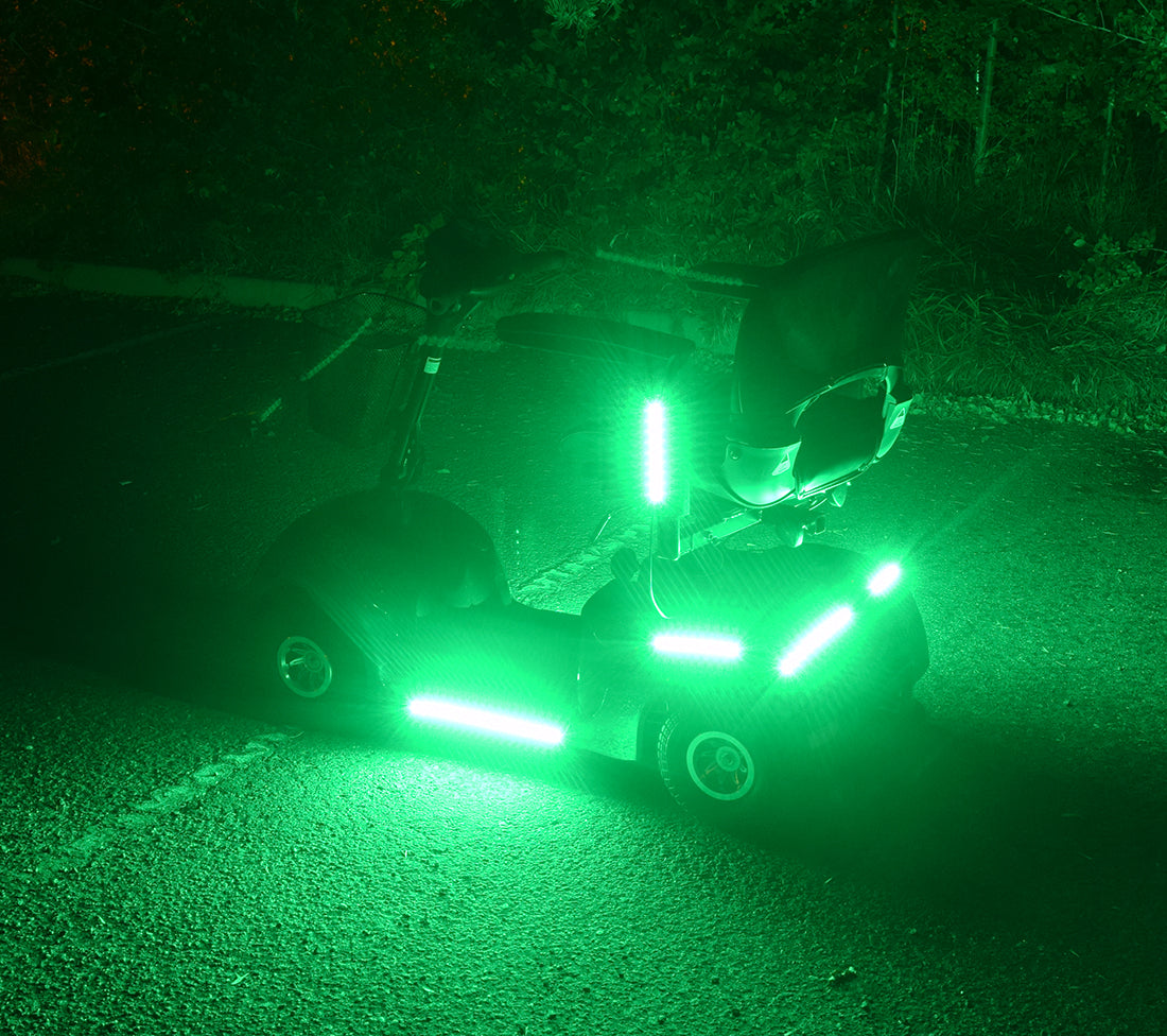 Multi-Color LED Light Kit for Pride Mobility Scooters attached to a scooter, showcasing a vibrant green light, designed for customizable and weather-resistant illumination with multiple lighting functions.