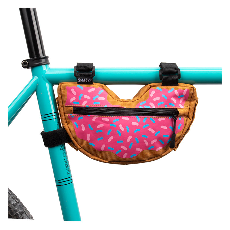 Doughnut Frame Bag for Bikes securely attached to a bicycle frame, showcasing a fun doughnut pattern with sprinkles and ample storage space, designed for easy mounting with three Velcro straps.