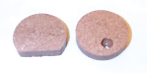 Close-up of Organic Brake Pads for Arctic Cat Snowmobiles (1980), showcasing the textured surfaces and round edges, indicative of their durable build for extreme temperatures and shock resistance.