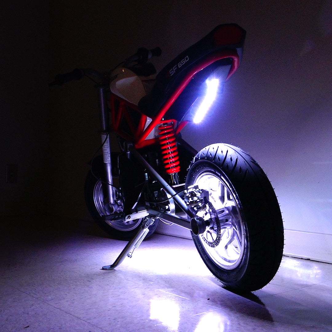 Multi-Color LED Light Kit for Razor Electric Bikes & Scooters, featuring a motorcycle wheel with a light on, highlighting the kit's vibrant illumination capabilities for enhanced visibility and style.