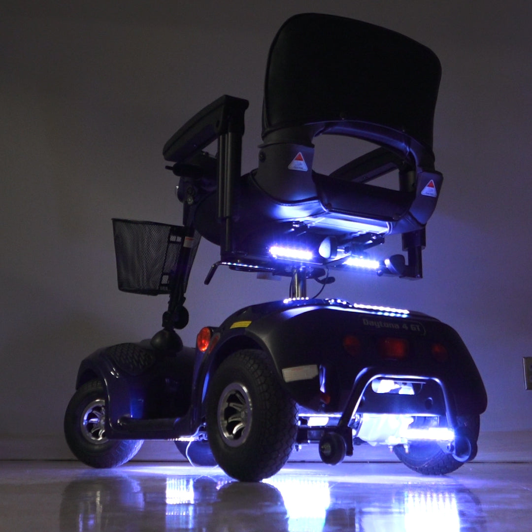 Multi-Color LED Light Kit for Mobility Scooters & Power Chairs shown installed, featuring multiple light strips illuminating a scooter wheel, enhancing visibility and style with vibrant, customizable lighting effects.