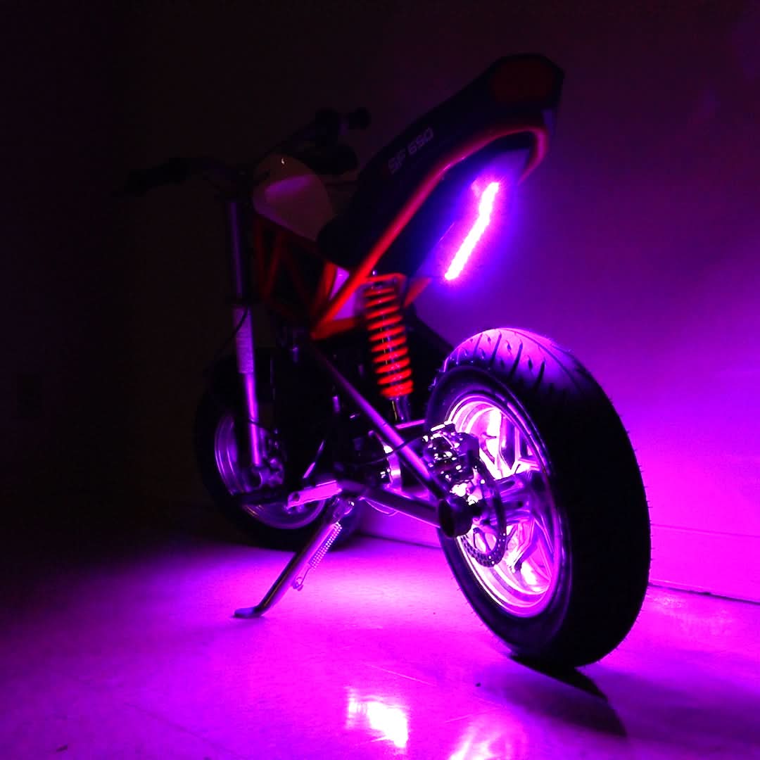 Multi-Color LED Light Kit for Razor Electric Bikes & Scooters, featuring purple lights illuminating a motorcycle's wheels, kickstand, and seat, creating a vibrant, glowing effect.