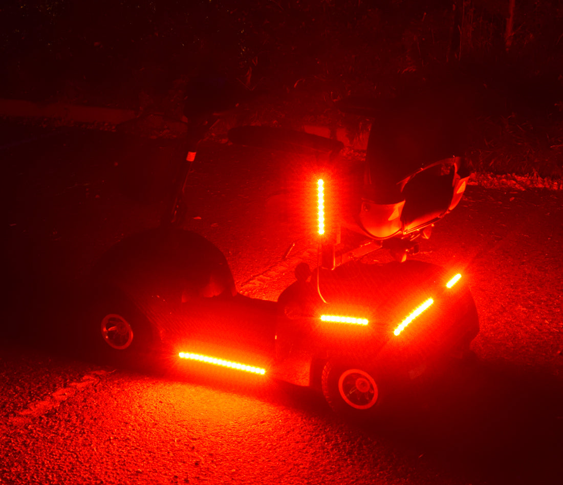 Multi-Color LED Light Kit for Pride Mobility Scooters, featuring red lights on a small vehicle, showcasing multiple light functions like solid, pulsing, and flashing, controlled via a remote.