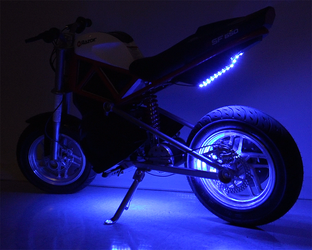 Multi-Color LED Light Kit for Razor Electric Bikes & Scooters, featuring a motorcycle with blue lights, close-up of the wheel, and kickstand, showcasing the vibrant, weather-resistant LED strips.