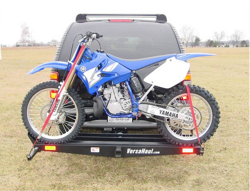 Single Scooter Carrier loaded with a blue motorcycle on the back of a truck, showcasing its robust design to safely transport two-wheel vehicles up to 500 lbs.