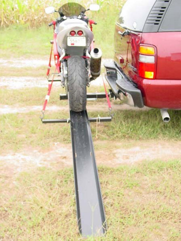 Sport Bike Carrier with Ramp from VersaHaul, featuring a motorcycle secured on a trailer attached to the back of a red car, highlighting the efficient transport solution.