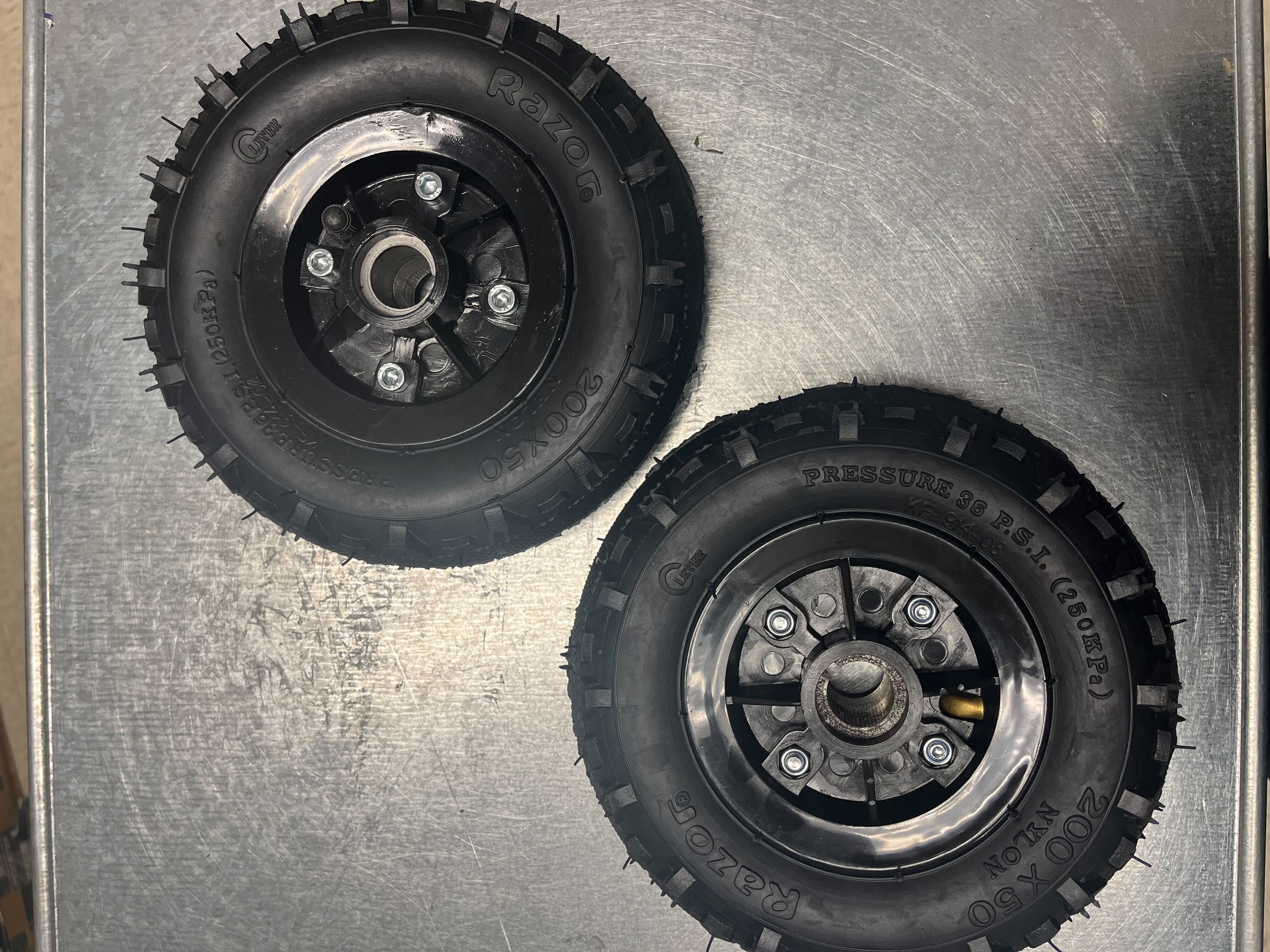 Razor Dune Buggy Rear Wheels (Set of 2) featuring black 8 tires with visible tread patterns and metal hubs. Ideal for replacements, these rear wheel assemblies enhance your Razor Dune Buggy's performance.