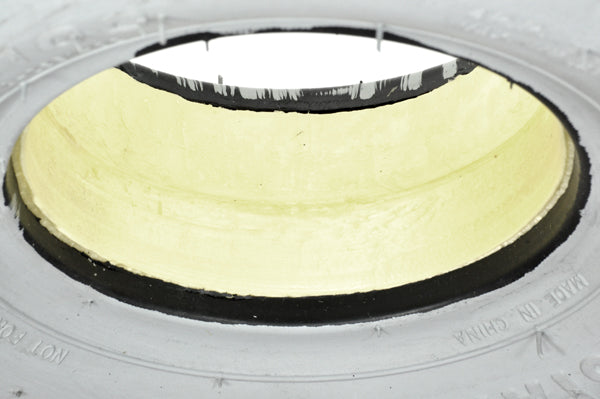 12x4 Foam-Filled Front Tire for Invacare Panther MX-4, featuring a non-marking gray rubber exterior and flush profile foam insert, shown in close-up against a plain background.