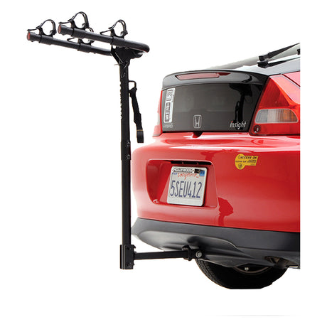 Commuter 2-Bike Hitch Rack mounted on the back of a red car, holding two bicycles securely with soft rubber cradles and integrated tie-down straps, showcasing its no wobble hitch pin.