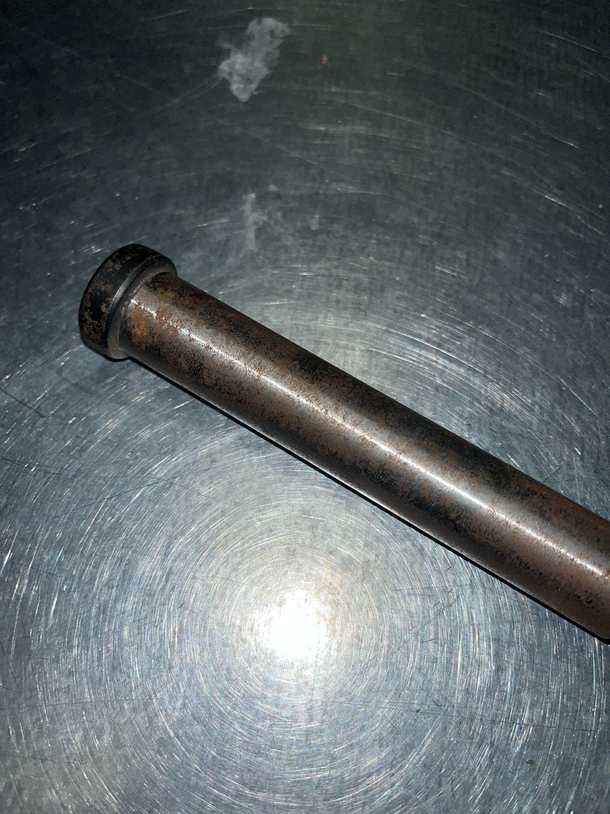 9.20 Sprocket Shaft for the Realtree RTK200 196cc Go-Kart (Blemished) on a metal surface, showing minor surface rust on the steel rod with a threaded end and stepped design.