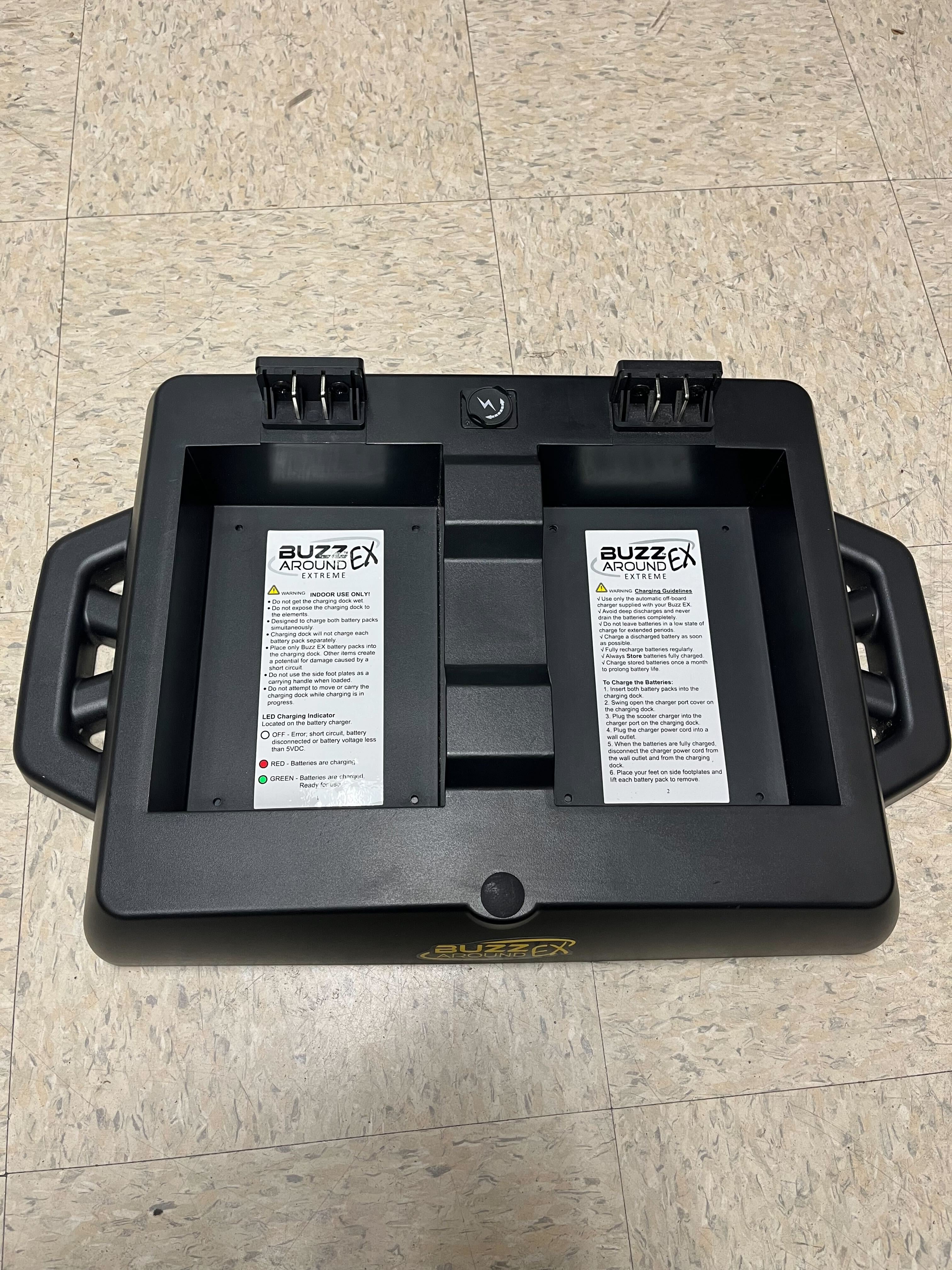 Battery Charging Dock for Golden Buzzaround EX (GB118/GB148) & Buzzaround LX (GB119/GB149) Scooters (Blemished) holding two batteries with labels, warning sign, and charging port.