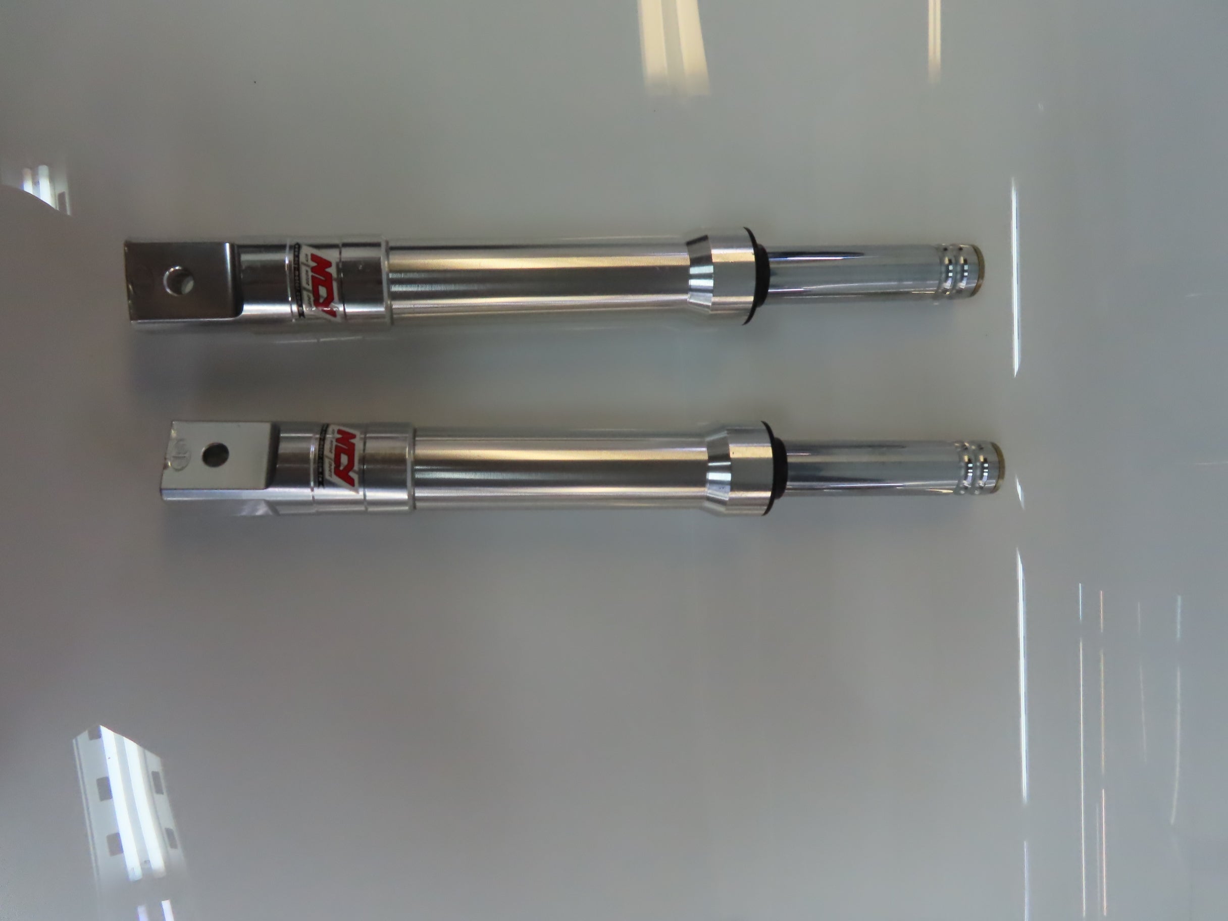 Front Forks for the Genuine Buddy 125 and Buddy 150 (Blemished) displayed as a pair of sleek metal cylinders on a white surface, showcasing their robust build and premium finish.