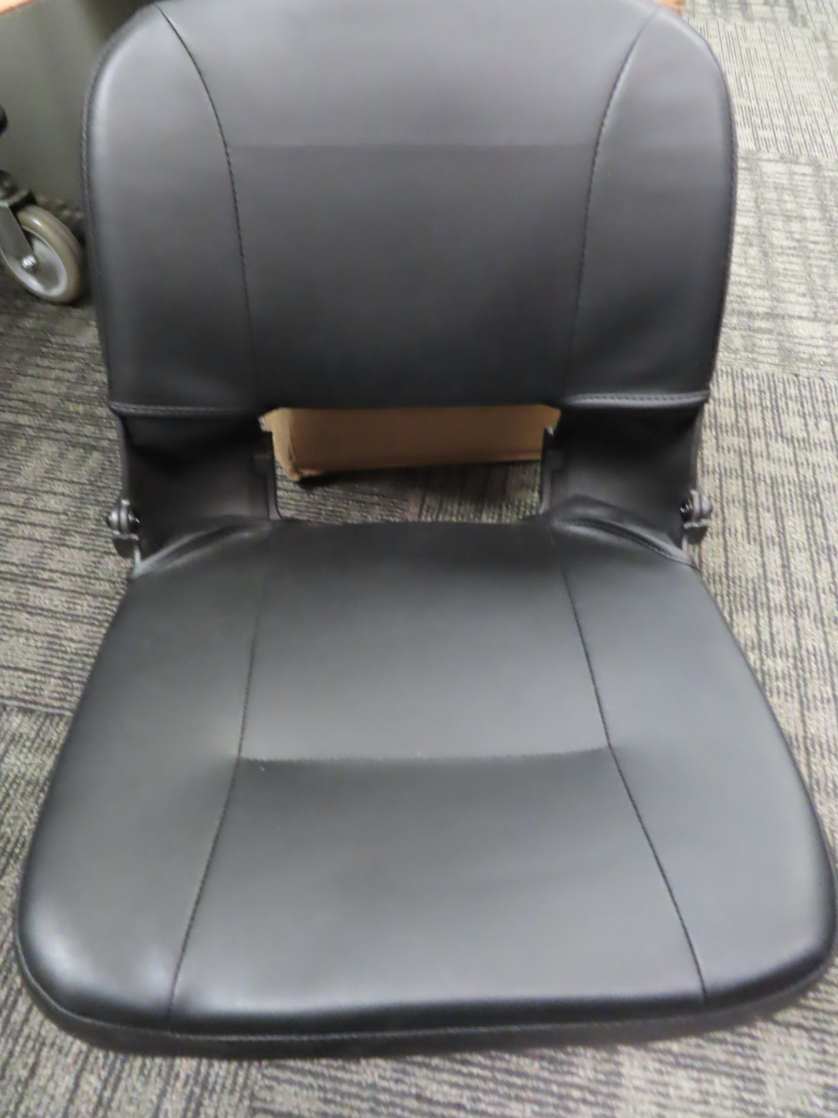 17 Wide Molded Seat Assembly for Go-Go and Pride Mobility Scooters, featuring a black chair with a hole in the back, black vinyl covers, and a close-up of a wheel on carpet.