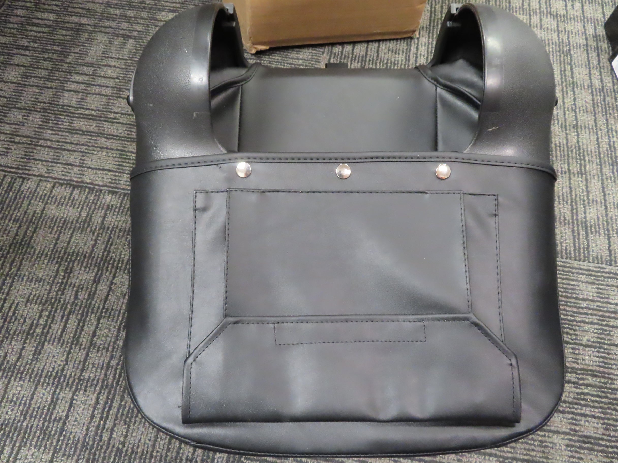 Black leather 17 Wide Molded Seat Assembly for Go-Go and Pride Mobility Scooters, displayed on a carpet, missing hardware. Includes seat back, base, black vinyl covers, foam inserts, and seat frame.