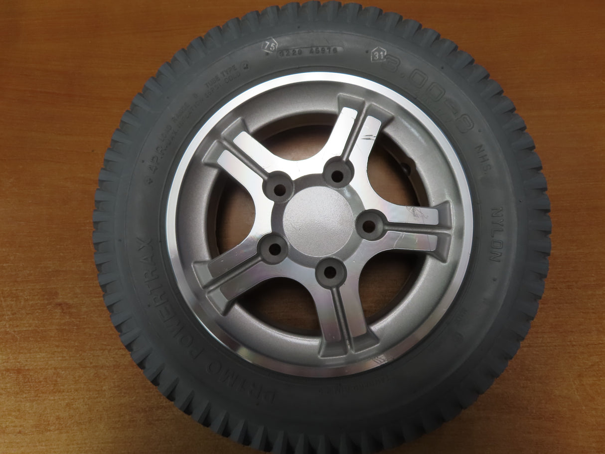 14x3 Flat Free 5-Spoke Wheel Assembly with Silver Rim for Quantum Q600, Q600XL, Q6000Z, and R4000 Power Chairs shown on a wooden surface, highlighting the tread and silver rim.