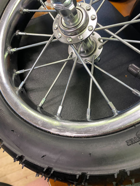 Front Wheel Assembly with Wire Spoke Rim for the Razor Pocket Mod (Versions 13+). Close-up image highlights metal spokes and tire, showcasing detailed craftsmanship and rugged design.