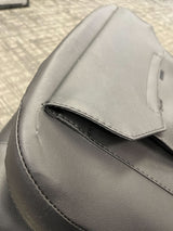 Close-up of an 18 Black Vinyl Molded Seat Assembly for Pride Mobility Scooters, showing the seat back, base, and armrests in detail.