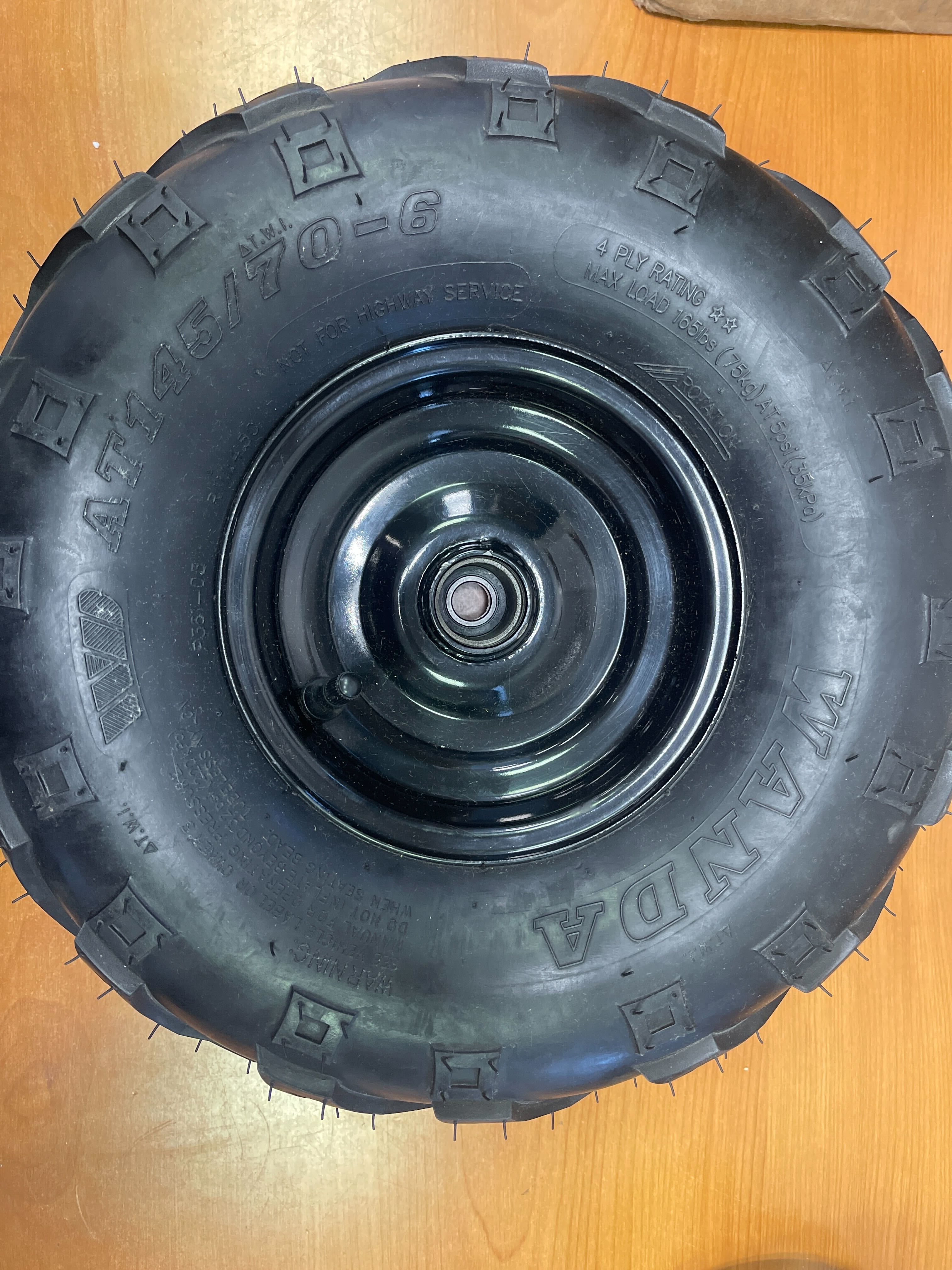 Front Left Wheel Assembly with Rim & Tire for Coleman KT196 & CK196 196cc 6.5 Hp Go-Karts, featuring a black tire with V-tread pattern mounted on a steel rim.