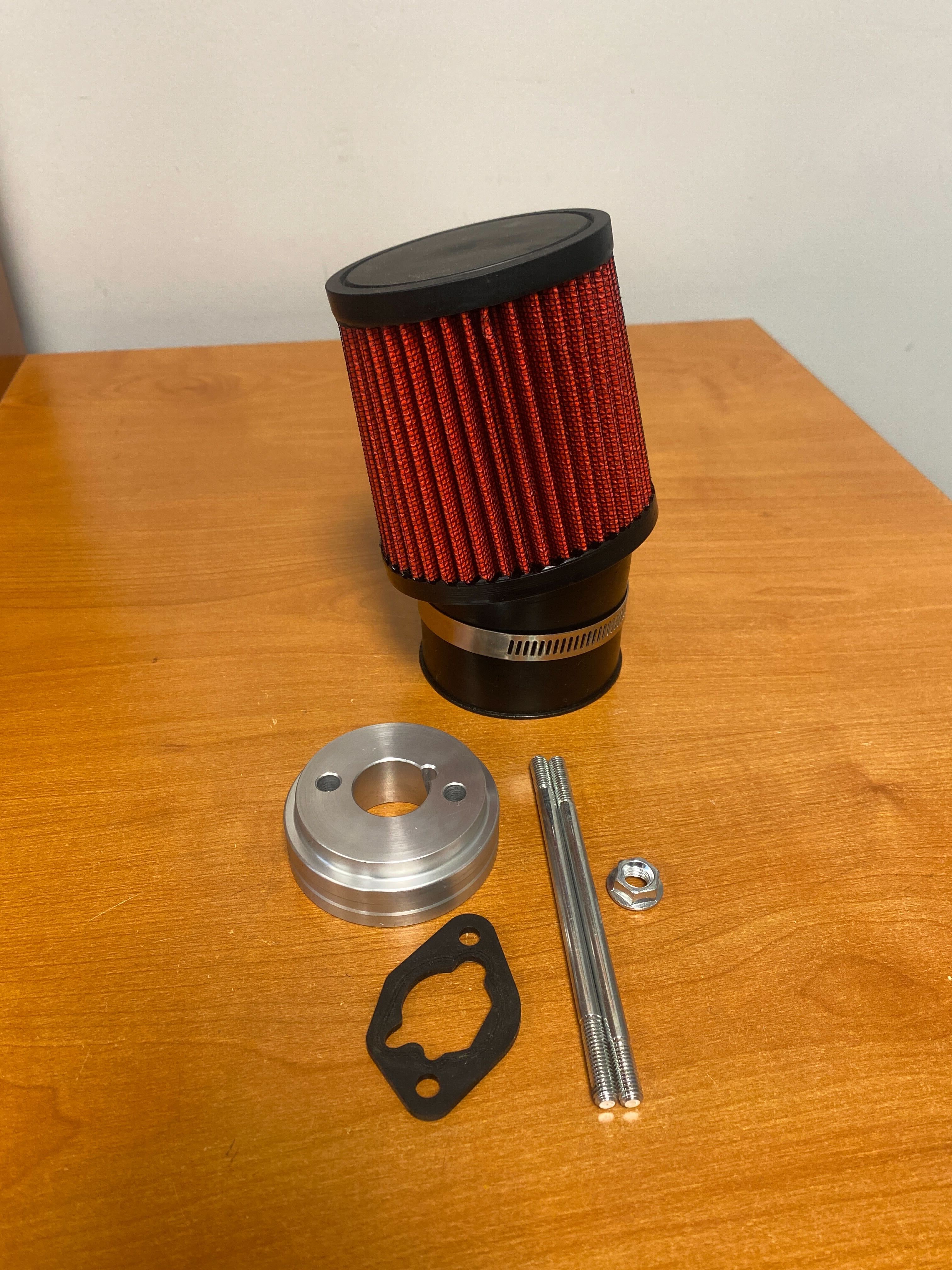 212cc 6.5 HP & 224cc HP Predator High Performance Air Filter Intake Kit (Missing Hardware) featuring a red and black air filter and metal components placed on a table.