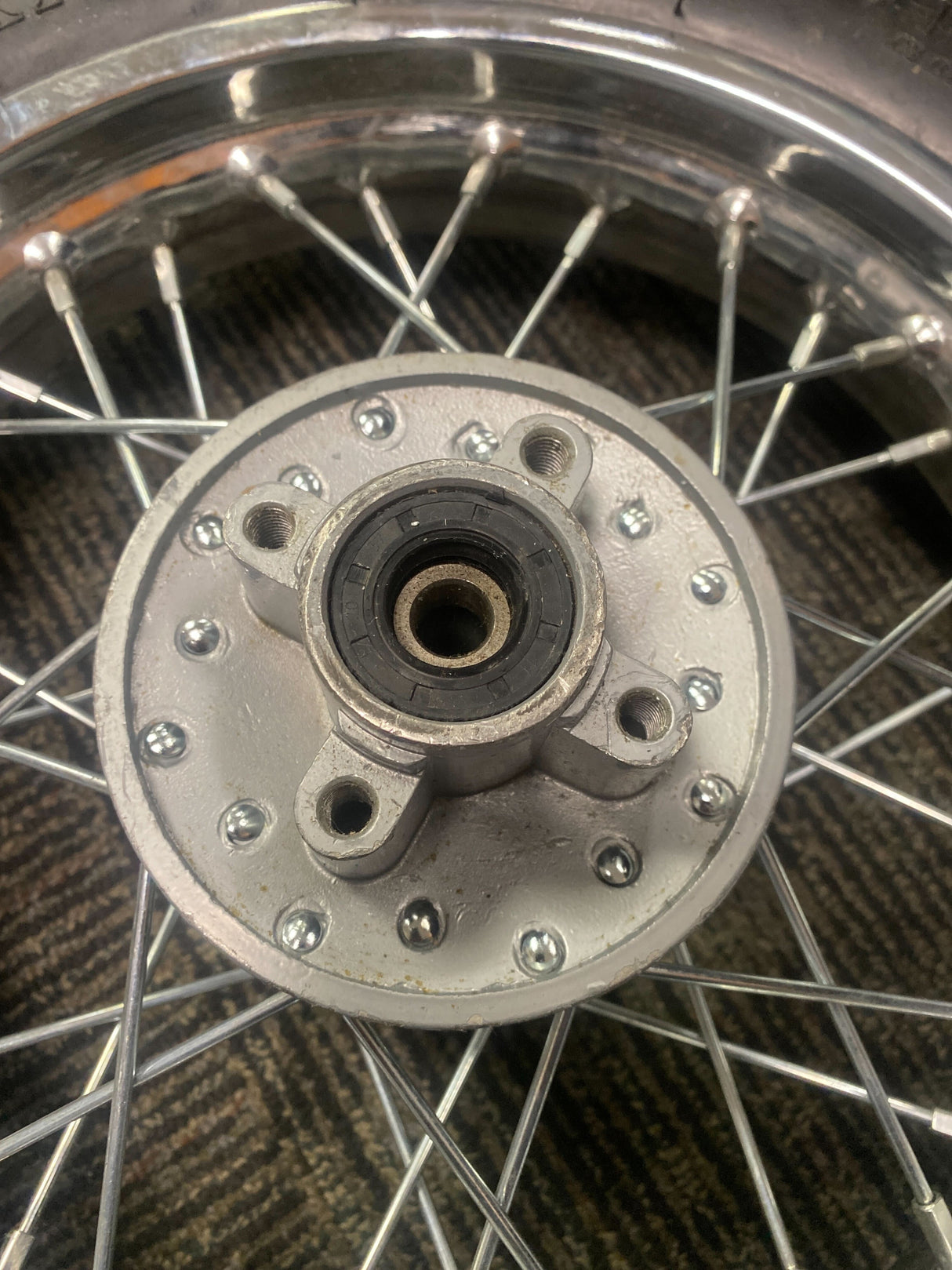 Close-up of a 12 (3.00-12) Rear Rim & Tire Wheel Assembly for Dirt Bikes with Disc Brakes (Version 1) (Blemished), showcasing the spoked rim and knobby tread tire.