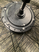 Rear Wheel Assembly with Hub Motor for the ANCHEER 26 350W Electric Mountain Bike (Blemished) showing a black wheel with spokes, close-up of screws, minor scratch on the hub, and slightly bent connector pins.