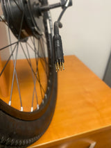 Close-up of the Rear Wheel Assembly with Hub Motor for the ANCHEER 26 350W Electric Mountain Bike (Blemished), highlighting the tire, spokes, and slightly bent connector pins.