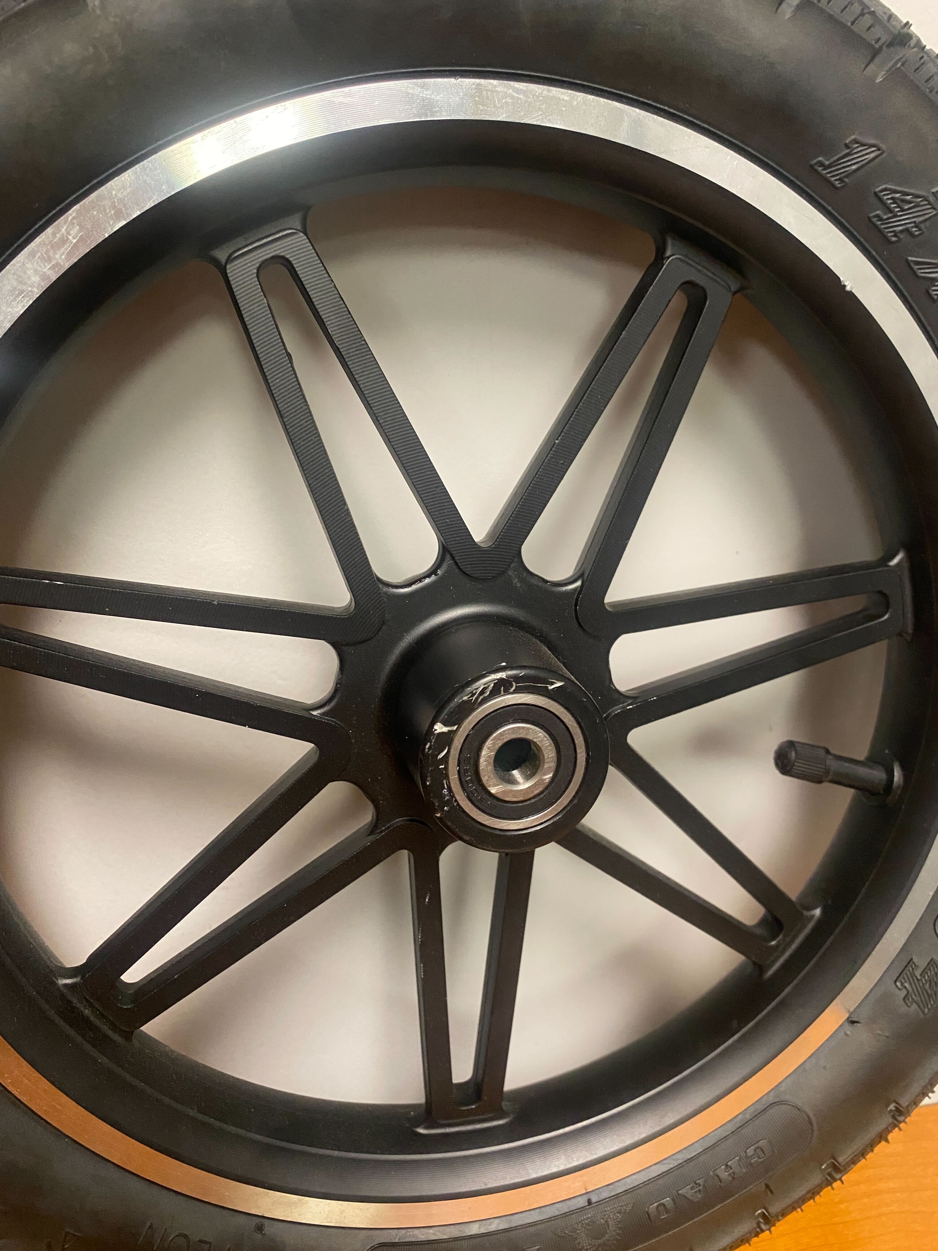 Front Wheel Assembly for the Swagtron EB5 Pro Electric Bike (Blemished) showing a close-up of the wheel, including the rim, 12 spokes, and a CST Rim Saver tire with visible mounting hub scratches.