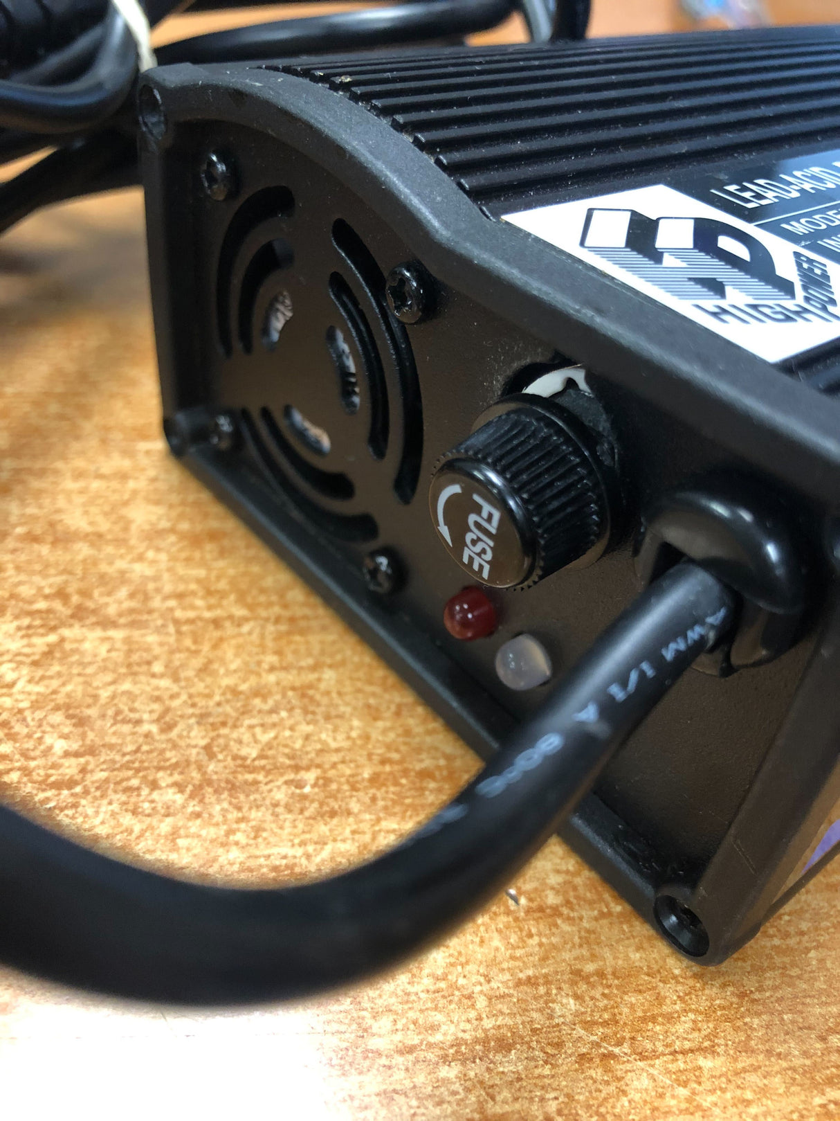 Close-up of the 24 Volt 5.0 Amp XLR HP8204B Battery Charger (Blemished) showing the black box, power cord, and fuse components.