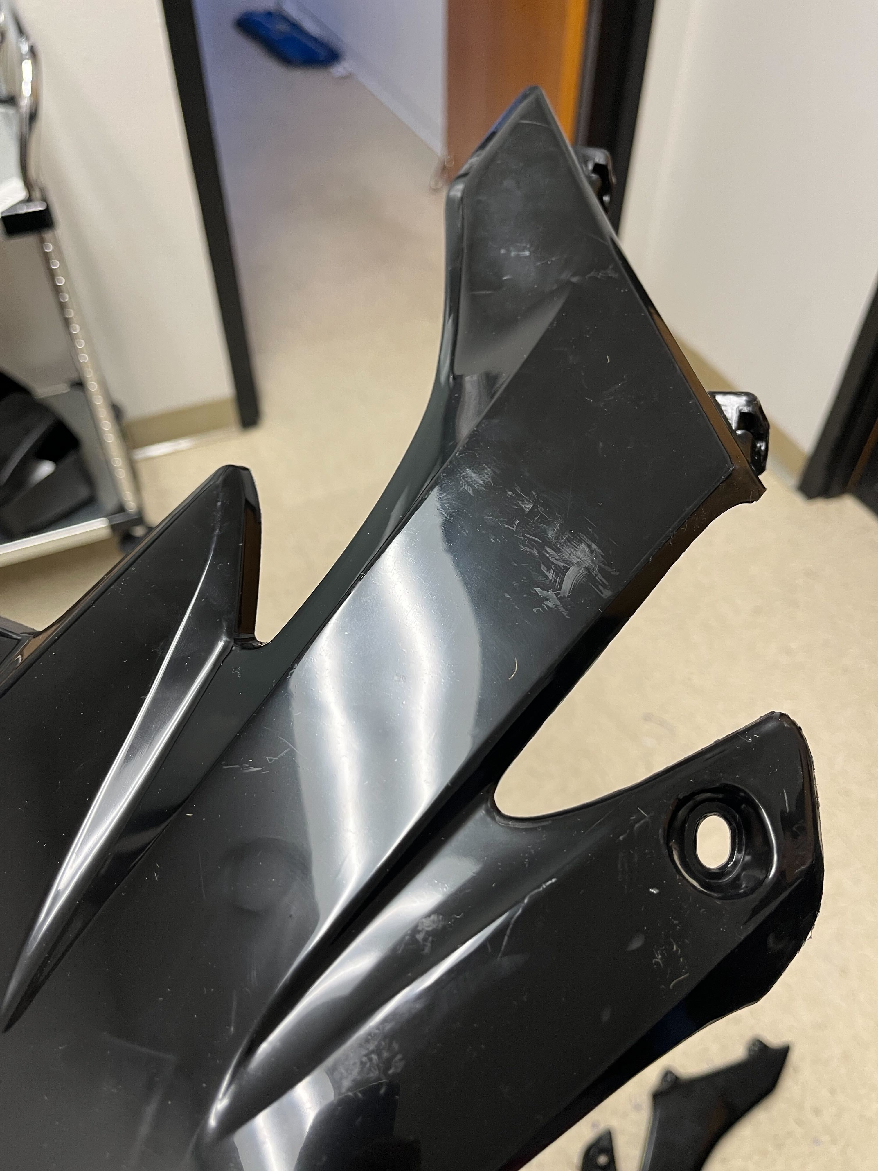 Honda CRF Style 50cc - 70cc Dirt Bike Fender & Body Panel Set (Small) (Black) (Blemished) featuring a black object with holes, suitable for rejuvenating tattered dirt bike parts.