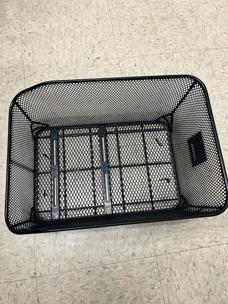Market-Style Rear Basket for Bicycles (Axiom) on a tile floor, showcasing its black vinyl-dipped steel wire mesh construction and open top design.