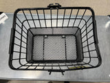 Lift-Off Wire Basket with Mesh Bottom (Blemished) on a table, showcasing its black metal frame and mesh bottom, ideal for bike or scooter accessories.