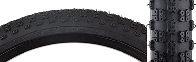 Close-up of a 20x1-1/8 MX3/C714 Bicycle Tire, featuring a knobby BMX tread and skin sidewalls, highlighting its durable black rubber composition and curved edge.