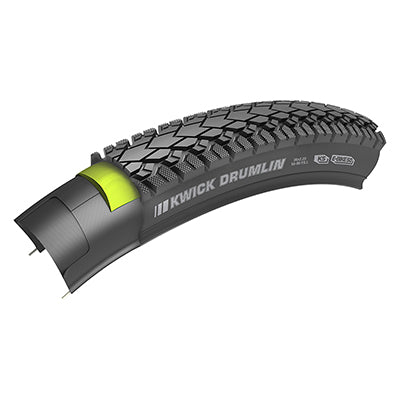 26x2.2 Reflective Kwick Drumlin Sport Bicycle Tire with a thick tread and a square profile, featuring a yellow light for visibility, ideal for diverse terrains including pavement, gravel, and forest roads.