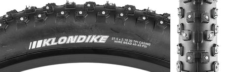 Close-up of the 27.5x2.1 Klondike Wide Sport Bicycle Tire, showcasing its tungsten carbide tipped studs and open square knob pattern designed for enhanced traction and snow shedding in icy conditions.