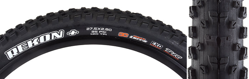 Close-up of a 27.5x2.8 Black/Black Rekon+ EXO/TR/TERRA Bicycle Tire, showcasing its well-spaced paddle-like knobs and large siped corners designed for varied terrain, with visible white text on the sidewall.