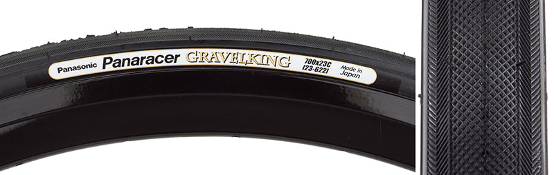 Close-up of a 700x23 Black/Black Gravel King Slick Bicycle Tire, featuring minimal tread and robust volume for versatile use on roads and gravel, with a white label visible on the tire.