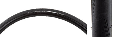 Close-up of a 700x25 One Bicycle Tire by Schwalbe, featuring smooth tread with siped shoulder grooves for improved traction and high-tensile micro fabric construction.