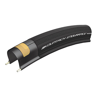 700x28 Reflective Kountach Endurance Pro Bicycle Tire close-up showcasing its smooth tread, lightweight design, and dual layer flat protection, with a visible black tube and yellow label.