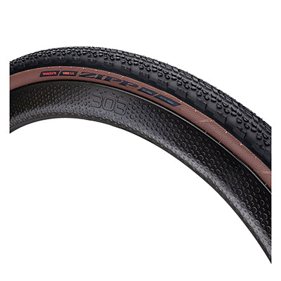 Close-up of the 700x40 Tangente Course G40 Bicycle Tire showing its Chevron center-tread pattern, inverted soccer cleat design, and aggressive cornering side knobs for control.