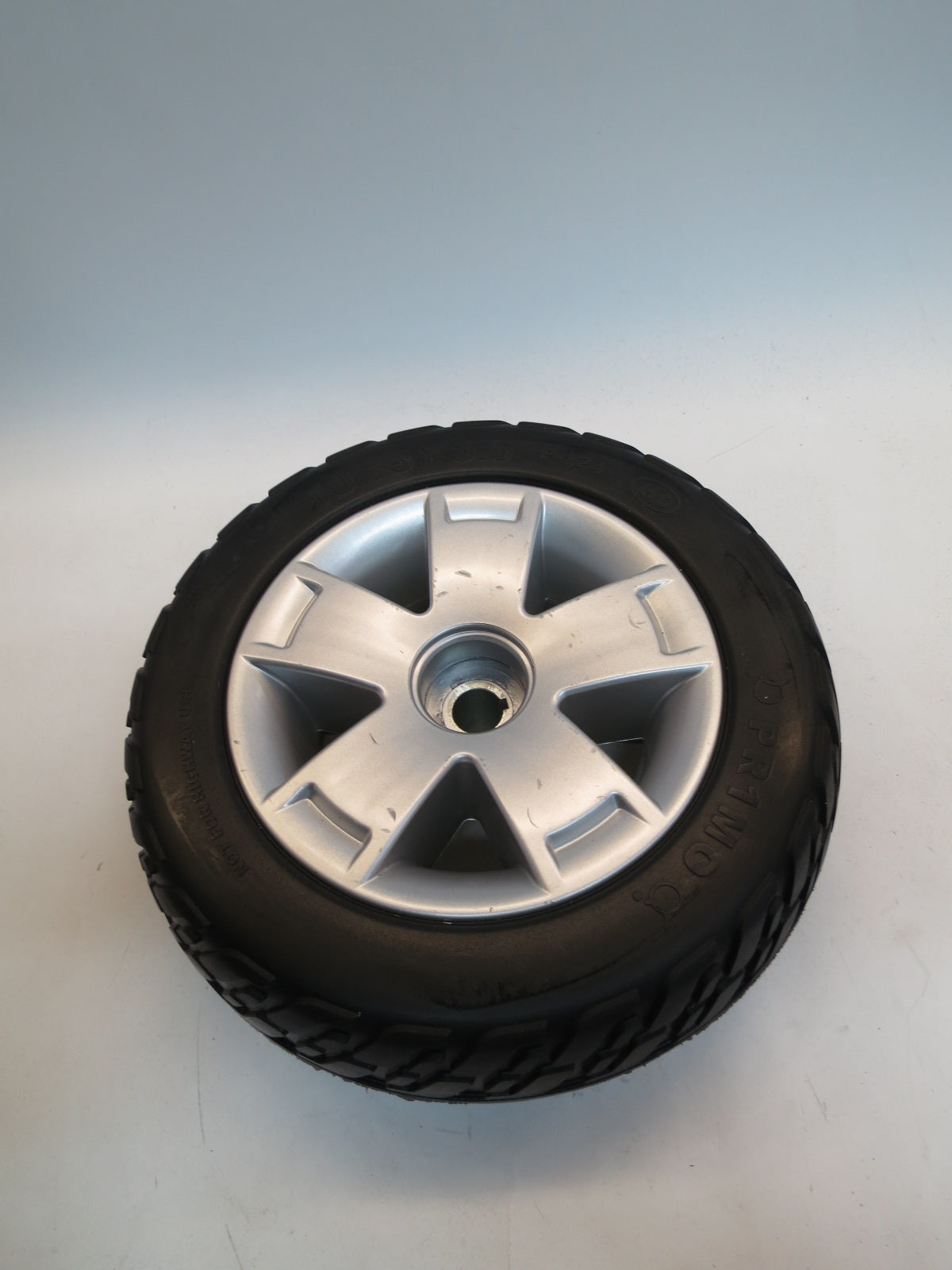 10.75x3.6 Flat-Free Black Rear Wheel Assembly for the Pride Maxima (SC900/SC940) featuring a black tire with a silver rim, designed for second-generation mobility scooters with specified serial numbers.