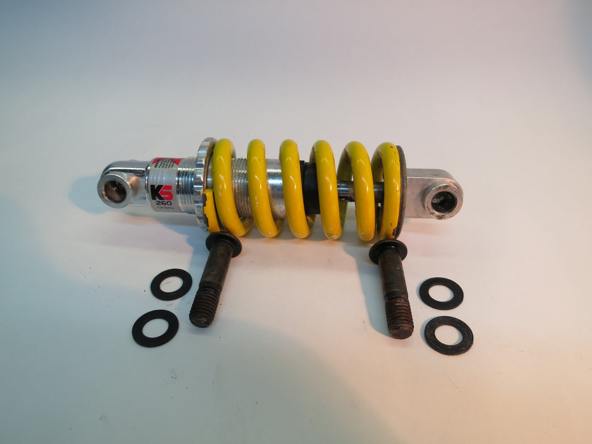 Front Strut/Shock Absorber Assembly for the Jazzy 614 HD (Used), featuring a yellow and silver coil spring with screws, suitable for left or right sides of the scooter.