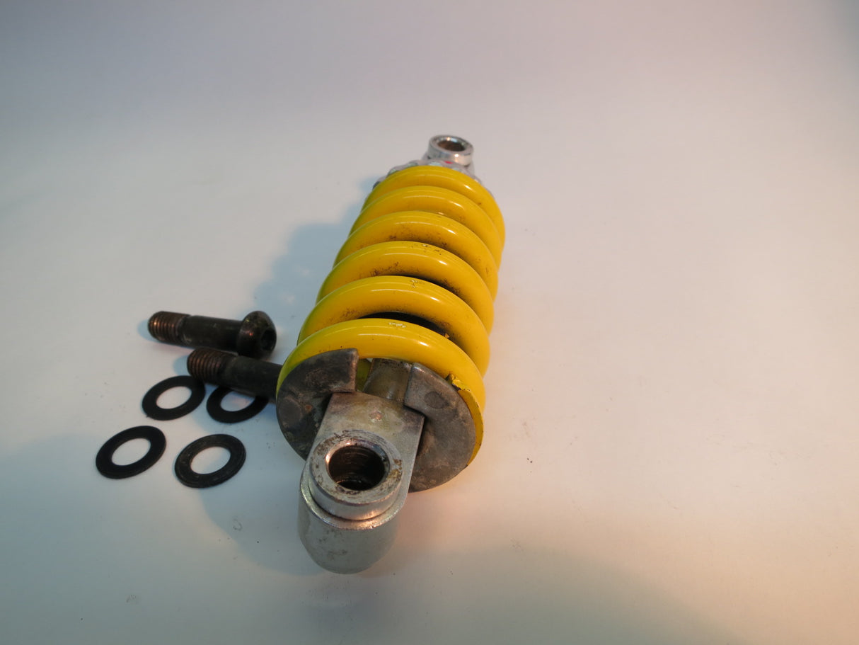 Front Strut/Shock Absorber Assembly for the Jazzy 614 HD (Used), featuring a yellow coil spring with attached screws and bolts, designed for both left and right sides of the mobility scooter.