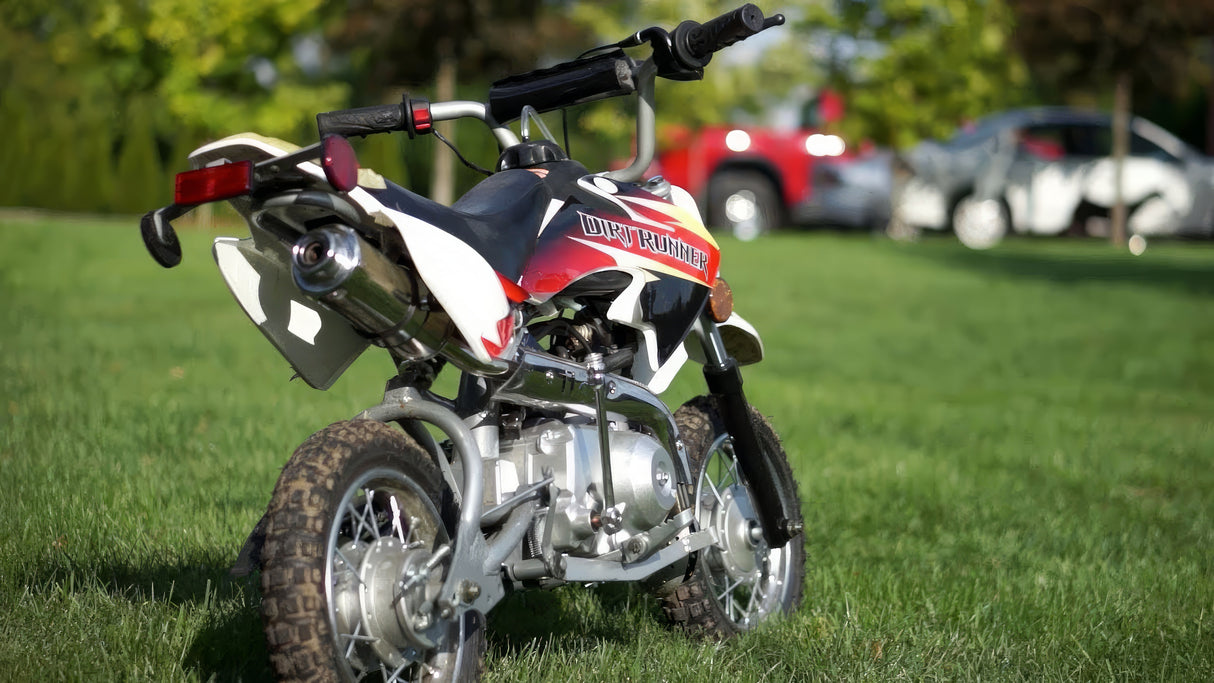 Training Wheels for 50cc & 70cc Dirt Bikes on a grassy field, showing close-up views of the wheels, mounting brackets, and axle, highlighting the product's sturdiness and essential components for attachment.