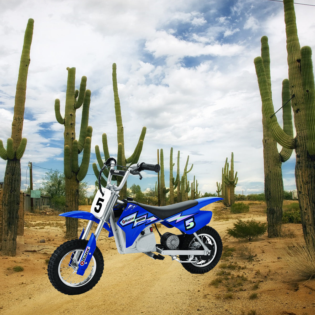 Blue Razor MX350 Dirt Rocket motorcycle in a desert setting. Visible close-up of a wheel and a white sign with a number. Suitable for 24 Volt Battery Pack, Versions 9+.